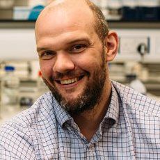 Headshot of Liam Grover in a lab setting